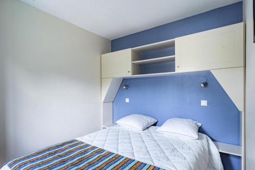 Bett mit blauem Kopfteil und 2 Kissen in der Unterkunft Résidence Lacanau Les Pins - maeva Home - Appartement 2 Pièces 5 Personnes 08 in Lacanau