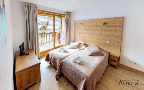 a bedroom with two beds and a large window at Chalet Villette - Magnifique logement composé de 8 chambres MAE-3744 in Saint-Martin-de-Belleville