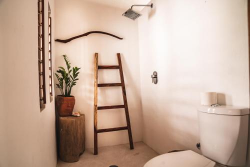 a bathroom with a ladder next to a toilet at Casa Chula Hotel Boutique Frente al Mar in Tierra Blanca