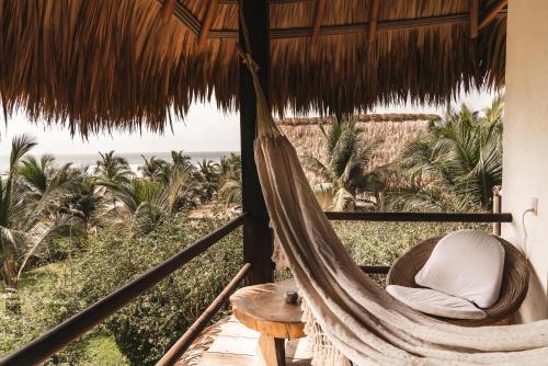 a hammock in a room with a view of the ocean at Casa Chula Hotel Boutique Frente al Mar in Tierra Blanca