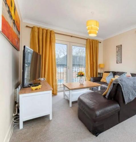 uma sala de estar com um sofá e uma televisão em Peaceful 3 Beds - Near Central London em Londres