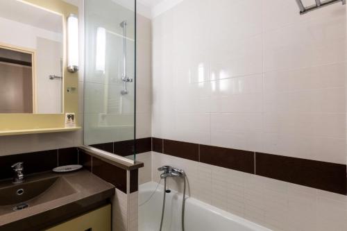 une salle de bain avec une baignoire, un lavabo et une douche dans l'établissement Résidence le Village de Cap Esterel - maeva Home - Appartement 2 Pièces 5 Personnes - Sélection MAE-9043, à Saint-Raphaël