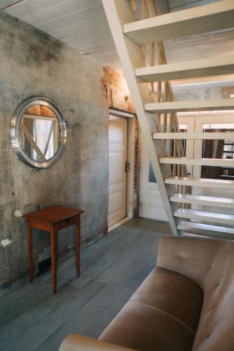 a living room with a staircase and a table at Kalnciema kvartāla Kuldīgas rezidence in Kuldīga