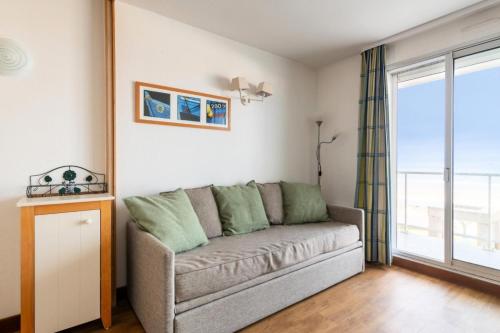 un salon avec un canapé et une fenêtre dans l'établissement Résidence Les Océanes - maeva Home - Studio 5 personnes vue mer - Sélection MAE-9254, à Pornichet