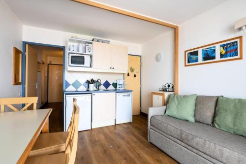 un salon et une cuisine avec un canapé et une table dans l'établissement Résidence Les Océanes - maeva Home - Studio 5 personnes vue mer - Sélection MAE-9254, à Pornichet