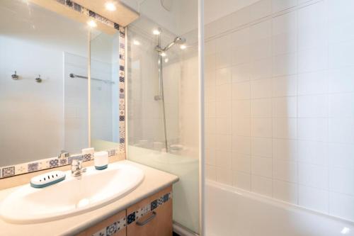 une salle de bain blanche avec un lavabo et une douche dans l'établissement Résidence Les Océanes - maeva Home - Studio 5 personnes vue mer - Sélection MAE-9254, à Pornichet