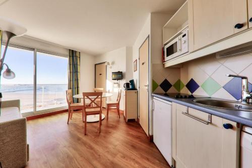 une cuisine et une salle à manger avec une table et des chaises dans l'établissement Résidence Les Océanes - maeva Home - Appartement 2 pièces 6 personnes Confort - vue mer MAE-9582, à Pornichet