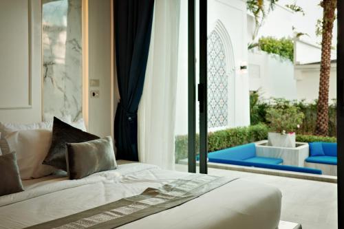a bedroom with a bed and a patio at Menara - 3 BR Private Pool Villa - Moroccan Inspired - Bangtao Beach in Phuket