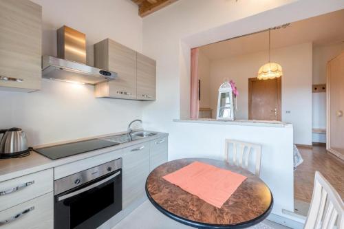 una cucina con tavolo e piano di lavoro di Garda Sol SPA Hotel & Appartamenti a Toscolano Maderno