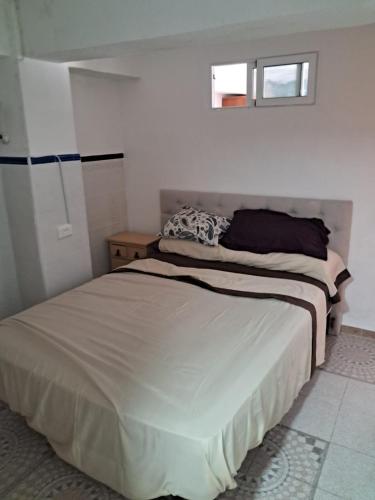 a small bedroom with a bed and a window at Apartamento Trafalgar in Xeraco
