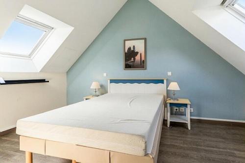 1 dormitorio con 1 cama y 2 mesas con lámparas en Résidence Cap Azur - maeva Home - Appartement 3 Pièces 7 Personnes - Confor 52 en Fouesnant