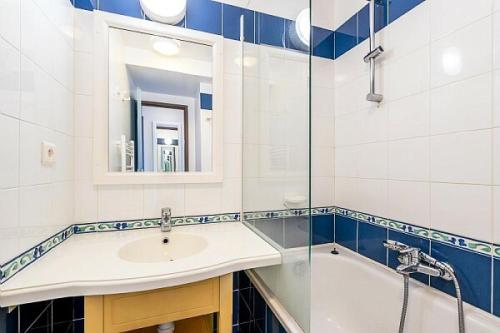 y baño con lavabo, bañera y espejo. en Résidence Cap Azur - maeva Home - Appartement 3 Pièces 7 Personnes - Confor 52 en Fouesnant