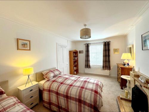 a bedroom with two beds and a window at Ameliafield Cottage, Prestwick in Prestwick