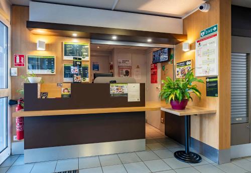 a lobby of a restaurant with a reception counter at B&B HOTEL Saint-Etienne La Terrasse in Saint-Étienne