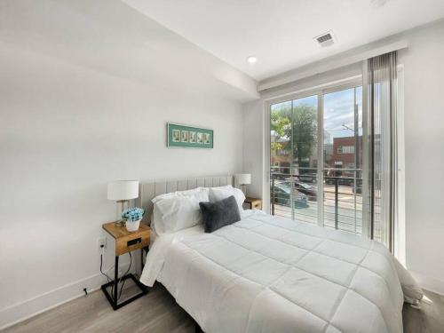 a white bedroom with a large bed and a window at Classy Capitol Hill APT, Steps from DC Attraction in Washington, D.C.