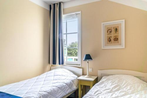 une chambre avec deux lits et une fenêtre dans l'établissement Les Maisons de Port Bourgenay - maeva Home - Maison 3 Pièces 6 Personnes - Sélection MAE-2694, à Talmont-Saint-Hilaire