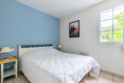 une chambre avec un grand lit blanc et une fenêtre dans l'établissement Résidence Port Bourgenay - maeva Home - Appartement 3 Pièces 7 Personnes - Sélection MAE-2704, à Talmont-Saint-Hilaire