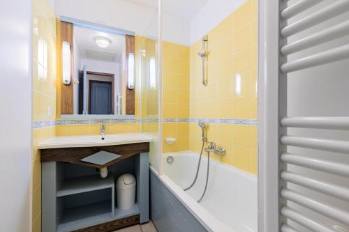une salle de bain avec un lavabo, une baignoire et un miroir dans l'établissement Résidence Port Bourgenay - maeva Home - Appartement 3 Pièces 7 Personnes - Sélection MAE-2704, à Talmont-Saint-Hilaire
