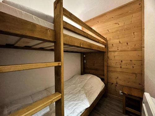 Ce lit se trouve dans un dortoir doté de 2 lits superposés et de murs en bois. dans l'établissement Résidence Courmayeur - Beau 2 pièces cabine Pied des pistes MAE-3934, aux Menuires