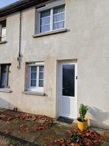 a house with a white door and a plant at Cocon cosy au cœur de Verneuil in Verneuil d’Avre et d’Iton