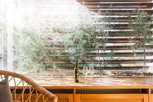 un tavolo con bicchieri e una bottiglia di vino di Elegant Maisonette 4BD Glyfada ad Atene
