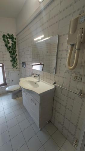 bagno con lavandino, specchio e servizi igienici di La Dimora dell'Ippocampo a Soverato Marina