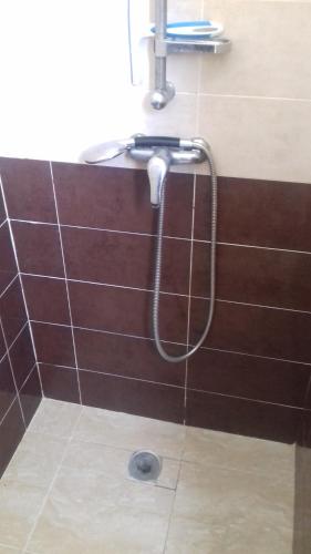 a shower in a bathroom with a hose on a wall at Dar Fati Roses in Aït Imouni