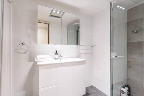 a white bathroom with a sink and a shower at Reid5 2BR Apartment Close to Glebe Park and Canberra City in Canberra