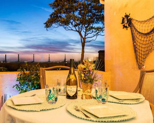 a table with a bottle of wine and glasses at 'Sunsets Over Catalina' - An Insider's Secret Hideaway with an Ocean View! in Dana Point