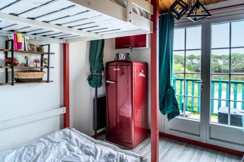 Cette chambre dispose d'une fenêtre et d'un petit réfrigérateur rouge. dans l'établissement Résidence Port Bourgenay - maeva Home - Appartement 2 pièces pour 4 personnes - Sélection MAE-5574, à Talmont-Saint-Hilaire