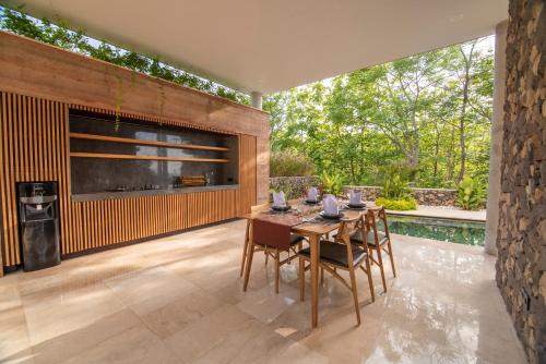 een eetkamer met een tafel en stoelen en een zwembad bij Villa Lantana in Umeanyar