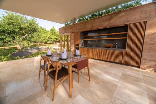 een eetkamer met een tafel en stoelen op een patio bij Villa Lantana in Umeanyar