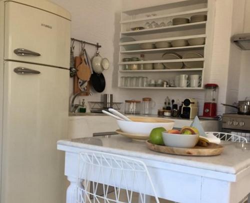 Stunning Antiparos Villa 3 Bedrooms Villa Kamino Breathtaking Sea Views في أنديباروس: مطبخ مع كونتر عليه صحون فواكه