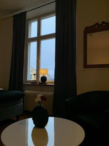 a living room with a table and a window at Best Guest Vandrarhem in Norrköping