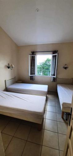 une chambre avec deux lits et une fenêtre dans l'établissement Les maisons Le Rouret - maeva Home - Maison 2 Pièces 5 Personnes - Confort MAE-3304, à Grospierres
