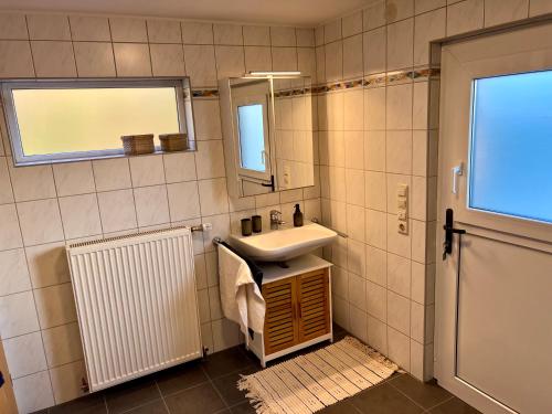 uma casa de banho com um lavatório e um espelho em Appartement „Zum Weißen Hahn“ em Bad Zwischenahn