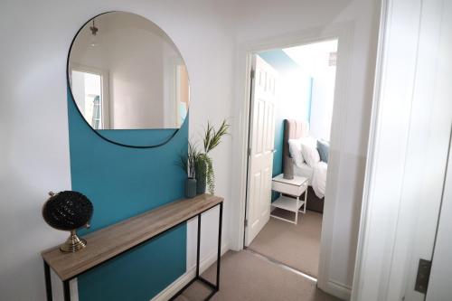 a hallway with a mirror and a table with a mirror at The Windsor Club Apartment in Leamington Spa