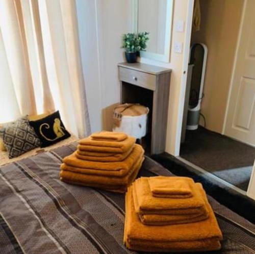 four towels on a bed in a room at Thorne Lodge - Seaview - 3 Bedroom in Whitstable