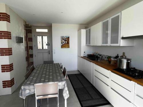 une cuisine avec une table et des chaises dans une pièce dans l'établissement Pornichétine pour 8 personnes face à l'océan et à 100m du marché, à Pornichet