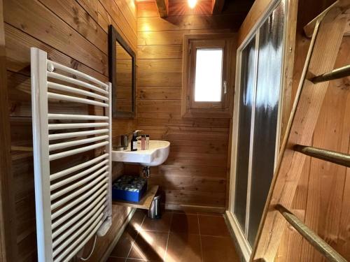 a bathroom with wooden walls and a sink and a window at Chalet Nubuck - Pièces 134 in Saint-Martin-de-Belleville