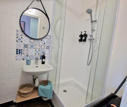 een badkamer met een douche, een wastafel en een spiegel bij Maisonnette en Duplex - Cosy- Centre Ville in Verneuil d’Avre et d’Iton