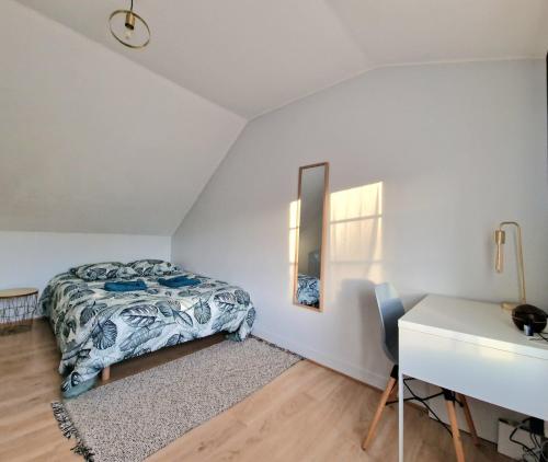 a bedroom with a bed and a desk and a mirror at Maisonnette en Duplex - Cosy- Centre Ville in Verneuil d'Avre et d'Iton