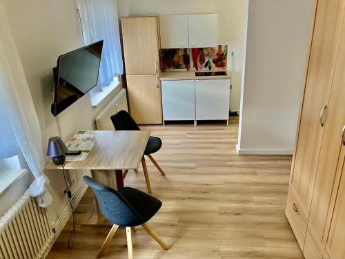 Habitación pequeña con mesa, sillas y cocina. en ZIMMERVERMIETUNG38 - Händel, en Salzgitter