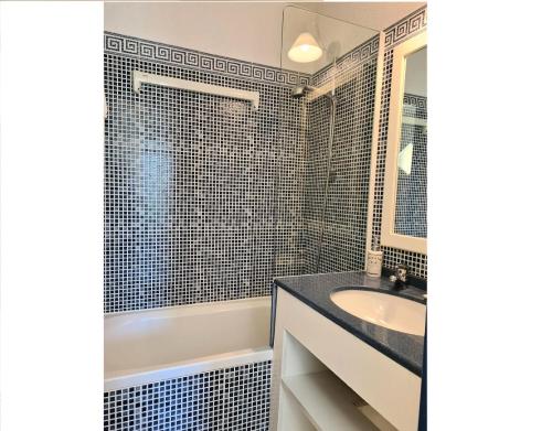 une salle de bain avec une baignoire, un lavabo et un miroir dans l'établissement Résidence Port Bourgenay - maeva Home - Appartement 2 Pièces 5 Personnes - Confort MAE-1824, à Talmont-Saint-Hilaire