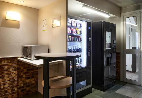 a bar with a table and a refrigerator at B&B HOTEL Saclay in Saclay