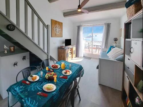 Cette chambre comprend une table avec des assiettes de nourriture. dans l'établissement Appartement face à la mer - Saintes-Maries-de-la-Mer, à Saintes-Maries-de-la-Mer