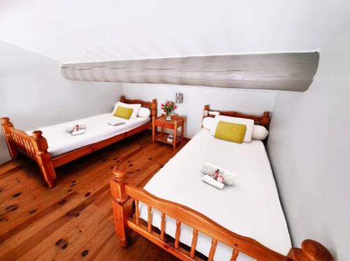 Habitación con 2 camas, paredes blancas y suelo de madera. en Appartement face à la mer - Saintes-Maries-de-la-Mer en Saintes-Maries-de-la-Mer
