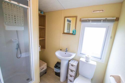 een kleine badkamer met een toilet en een wastafel bij SBL70 - Camber Sands Holiday Park - Sleeps 8 - Close swimming pools and facilities - Private Parking in Camber