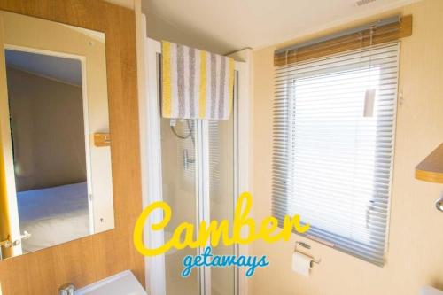 a bathroom with a sink and a mirror and a window at SP90 - Camber Sands Holiday Park - Dog Friendly in Camber