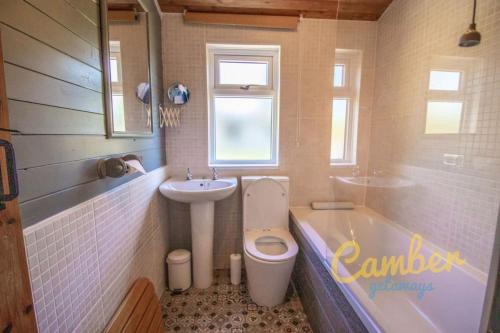 y baño con aseo, lavabo y bañera. en Five Waterings - Luxury Lodge en Brookland